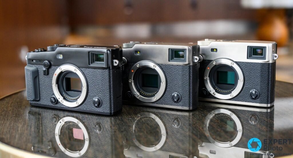 Trois boîtiers Fujifilm de la série X-Pro alignés sans objectif, finitions noir, charbon et argent, montures X visibles.