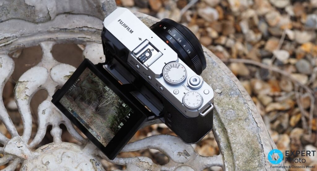 Fujifilm X-E4 vu de dessus, molette de vitesses graduée, griffe flash, boutons et bague de diaphragme du XF 27mm.
