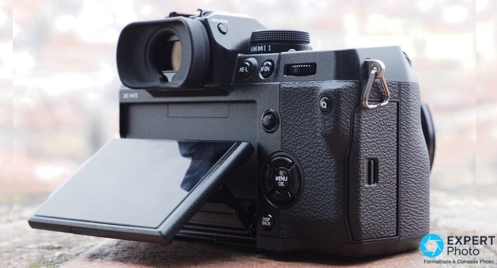 Fujifilm X-H1 vu de 3/4 arrière, viseur électronique avec œilleton et écran LCD inclinable déployé vers le bas.