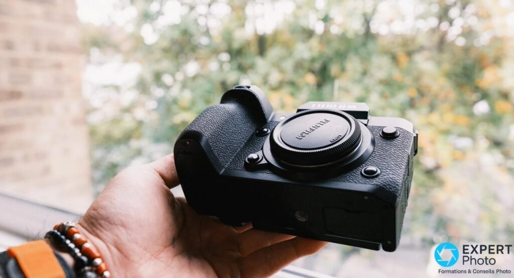Fujifilm X-H2 vu de dessus avec body cap monté, molette des modes et écran LCD supérieur visibles.