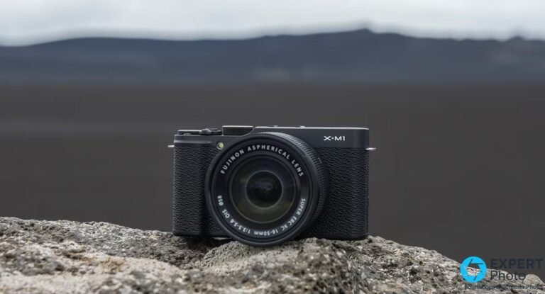 Fujifilm X-M1 : faut-il encore l’acheter d’occasion en 2026 ? Fujifilm X-M1 noir vu de face, marquage X-M1 visible, objectif Fujinon Aspherical Lens XC 16-50 mm monté