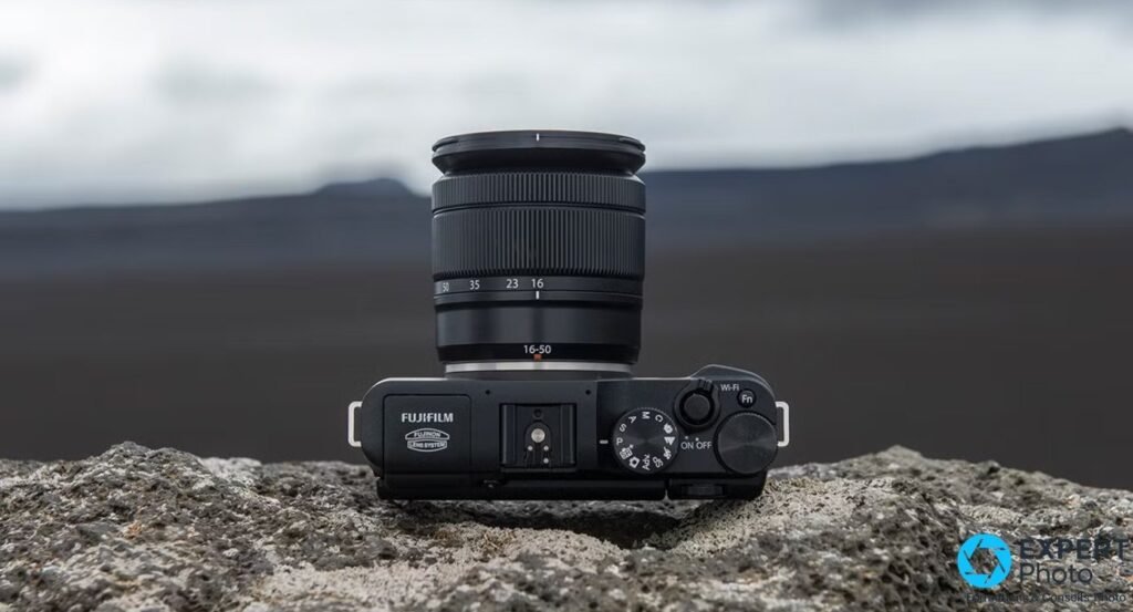 Vue plongeante du Fujifilm X-M1 avec marquage FUJIFILM lisible et objectif Fujinon XC 16-50 mm aux focales 50 35 23 16 mm