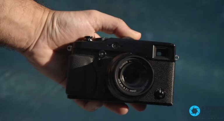 Fujifilm X-Pro1 noir tenu dans une main droite, équipé d'un objectif Fujinon XF 35 mm f/2 R WR