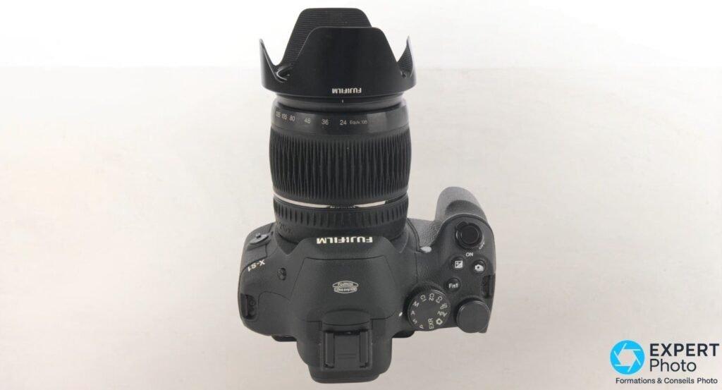 Fujifilm X-S1 vu de dessus, barillet du zoom déployé avec échelle des focales et logo Fujinon Lens System. 