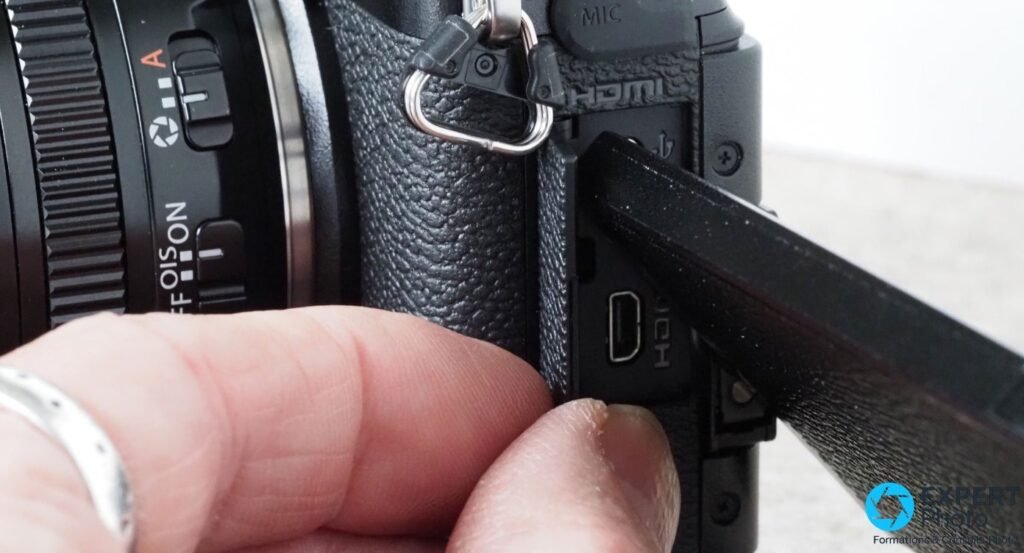 Côté du Fujifilm X-S10, cache latéral ouvert, port micro-HDMI visible avec marquages HDMI et MIC.