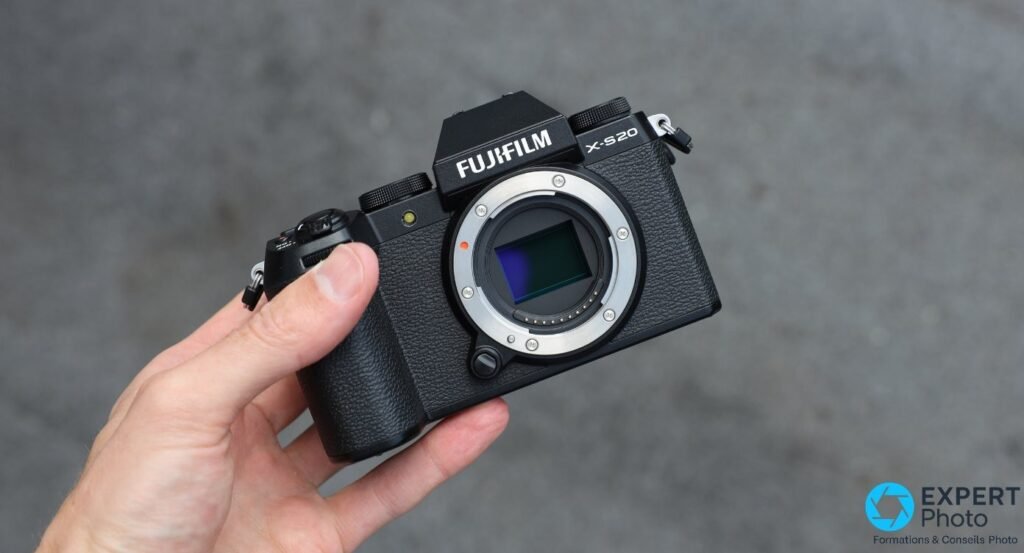 Fujifilm X-S20 boîtier nu tenu en main, monture Fujifilm X exposée et capteur APS-C visible