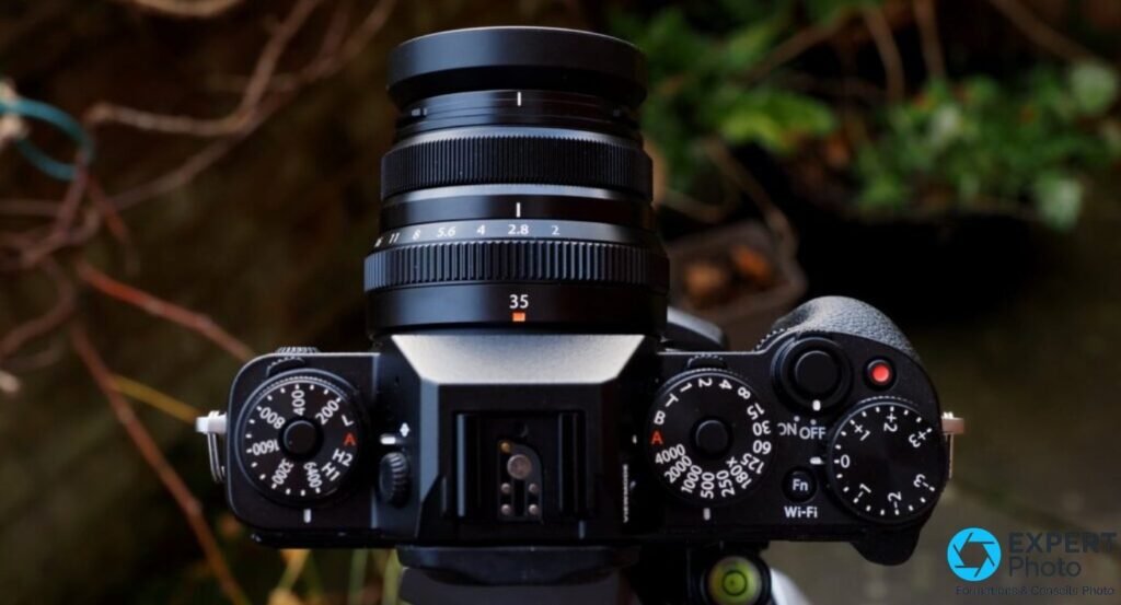 Fujifilm X-T1 sans objectif sur trepied, monture Fujifilm X et capteur APS-C X-Trans CMOS II visibles