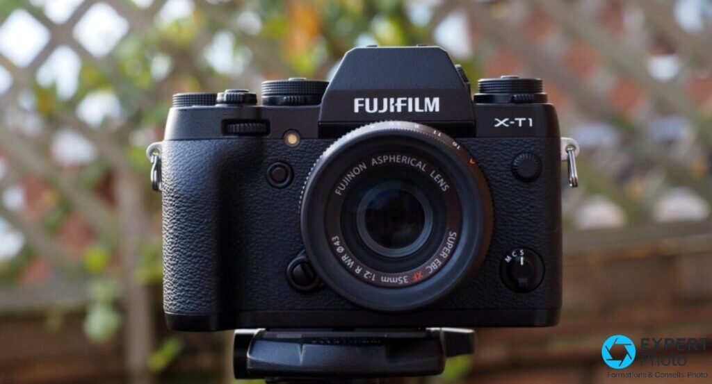 Plan rapproche du Fujifilm X-T1 montrant les molettes ISO, vitesse et compensation, prisme avec logo FUJIFILM