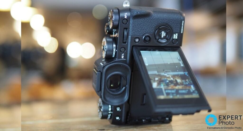 Profil droit du Fujifilm X-T2 avec écran orientable basculé vers le haut, molettes et viseur visibles latéralement.