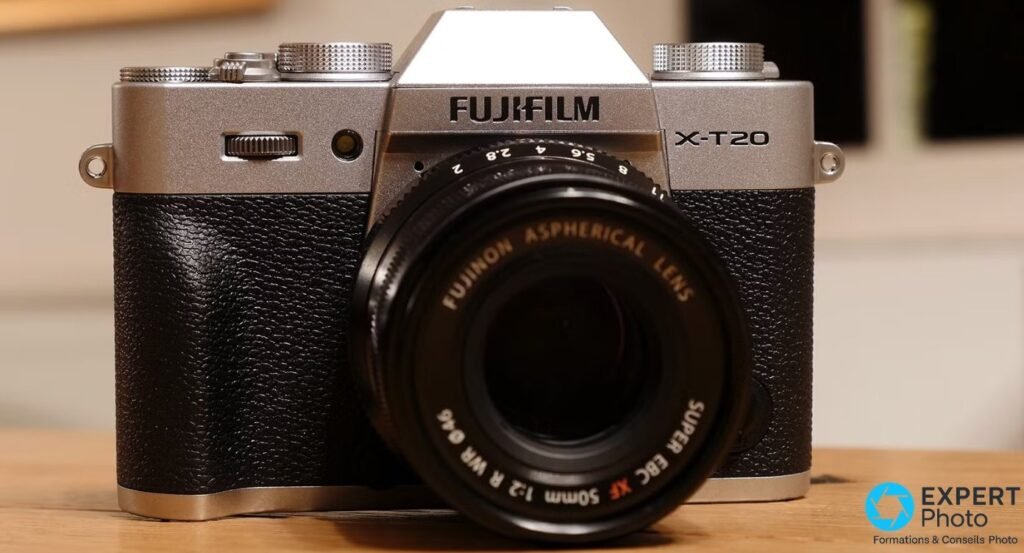 Fujifilm X-T20 argenté avec objectif fixe XF 50mm f/2 R WR posé sur surface bois, vue frontale