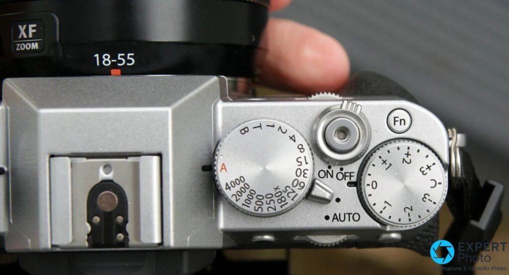Vue de dessus du Fujifilm X-T20 montrant griffe flash, molette vitesses, déclencheur, bouton Fn et molette compensation