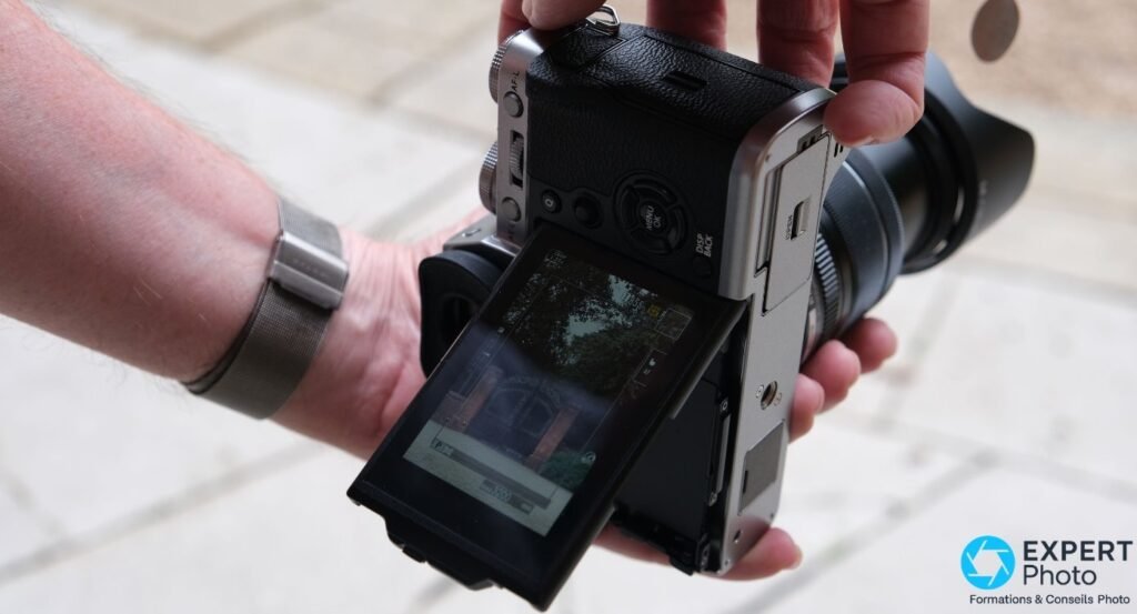 Fujifilm X-T3 vu de dos avec écran LCD inclinable sorti vers le bas, prise de vue de hanche en extérieur urbain