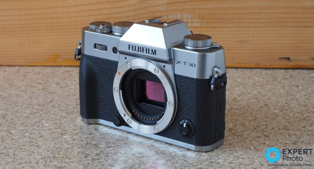 Fujifilm X-T30 II silver boîtier nu vu de face 3/4, monture X ouverte avec capteur APS-C visible.