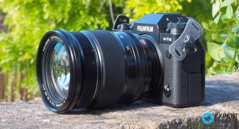 Fujifilm X-T4 : avis 2026, faut-il encore l’acheter ? Boîtier Fujifilm X-T4 noir avec objectif Fujinon XF 16-55 mm f/2.8 posé sur un mur de pierre, fond végétal vert flou.