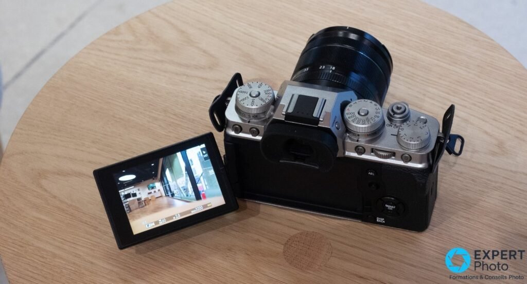 Fujifilm X-T4 silver vu de dessus avec écran articulé déployé latéralement, objectif Fujinon XF 18-55 mm monté.
