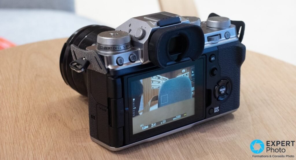 Dos du Fujifilm X-T4 silver avec écran LCD allumé affichant l'OSD en mode prise de vue, oculaire visible.