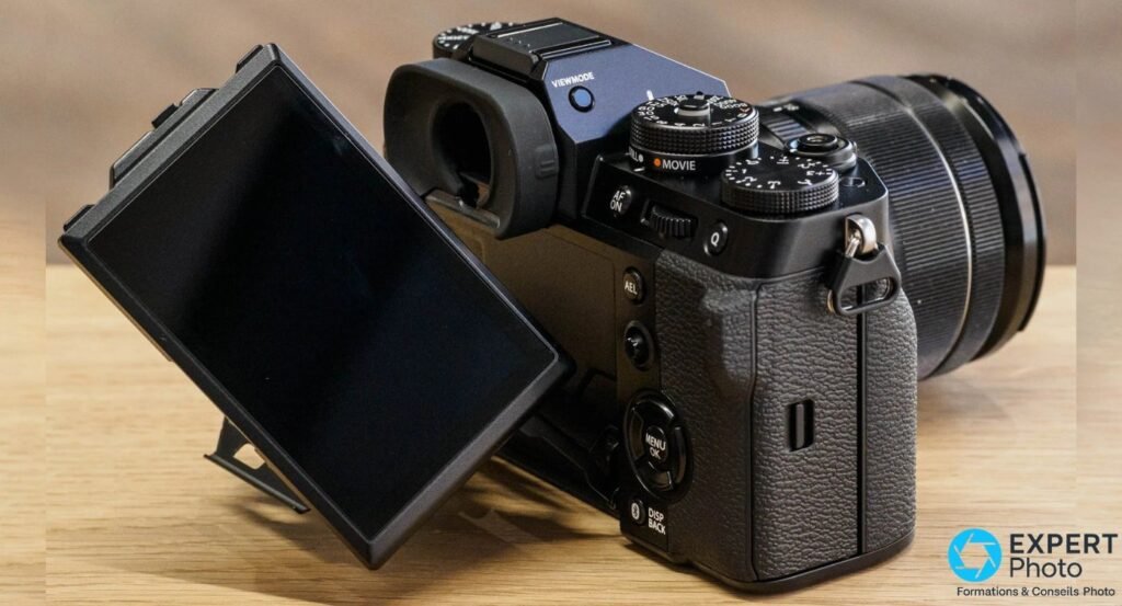 Écran tactile trois axes du Fujifilm X-T5 pivoté pour le cadrage vertical, charnière mécanique 3 axes visible.