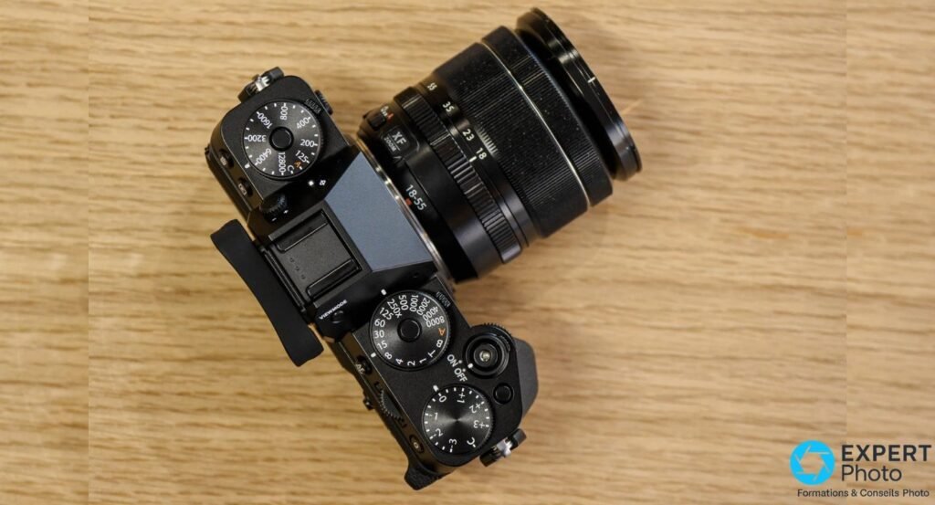 Fujifilm X-T5 vu de dessus avec molettes ISO, vitesse et compensation d'exposition, objectif XF 18-55 monté.
