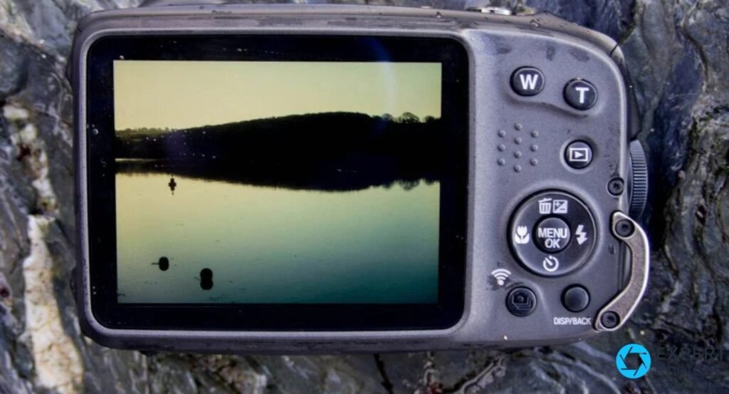 Face arrière du Fujifilm XP130 : écran 3 pouces sur un paysage de lac, boutons W/T, MENU/OK, lecture et DISP/BACK