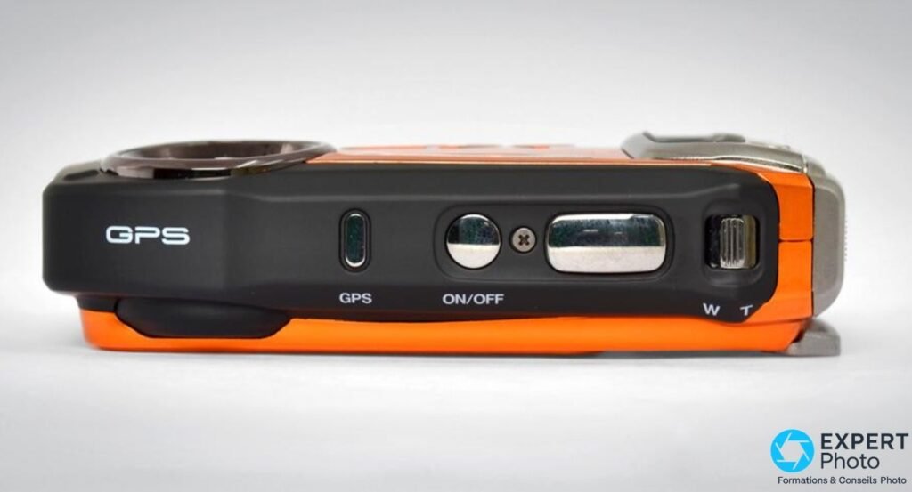 Vue de dessus du Fujifilm XP150 orange : bouton GPS, ON/OFF, levier de zoom W/T et objectif sur le capot supérieur.