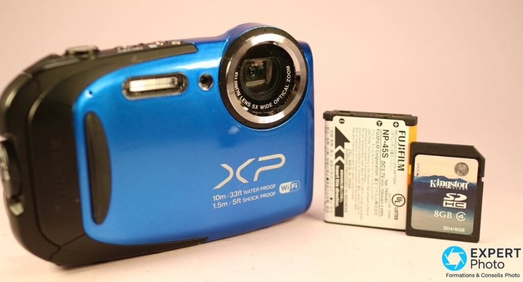 Fujifilm XP70 bleu de face avec batterie Fujifilm NP-45S et carte SDHC Kingston 8 Go classe 4 posées à droite