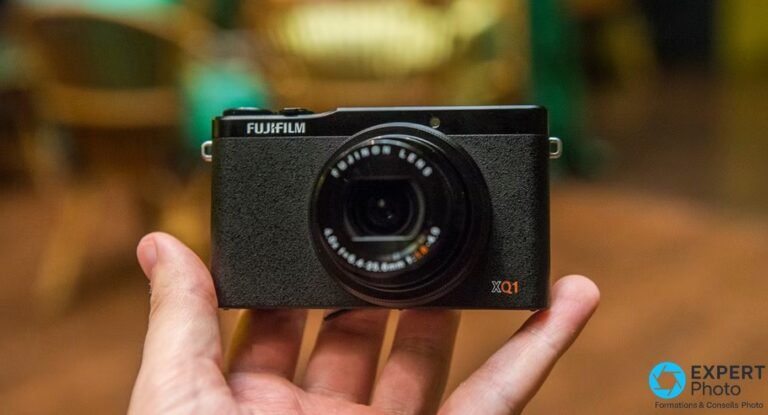 Test Fujifilm XQ1 : un compact expert qui tient encore en occasion Compact Fujifilm XQ1 noir vu de face, objectif rétracté, marquage FUJIFILM et logo XQ1 en orange lisibles, tenu en main.
