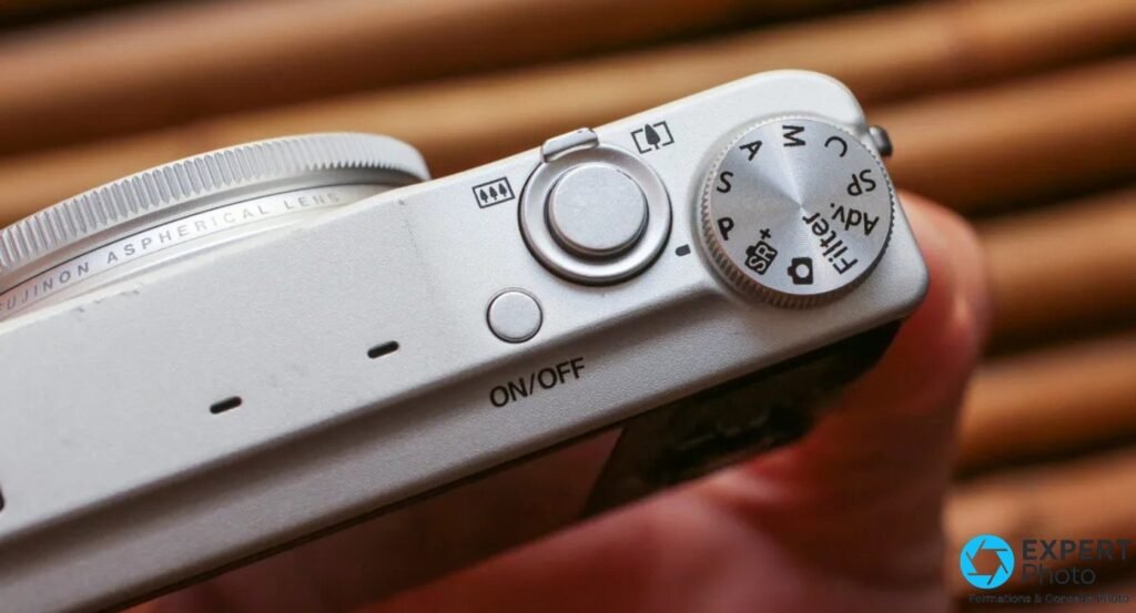 Fujifilm XQ2 silver vu de dessus, gros plan sur la molette de mode PASM, déclencheur et bouton ON/OFF.