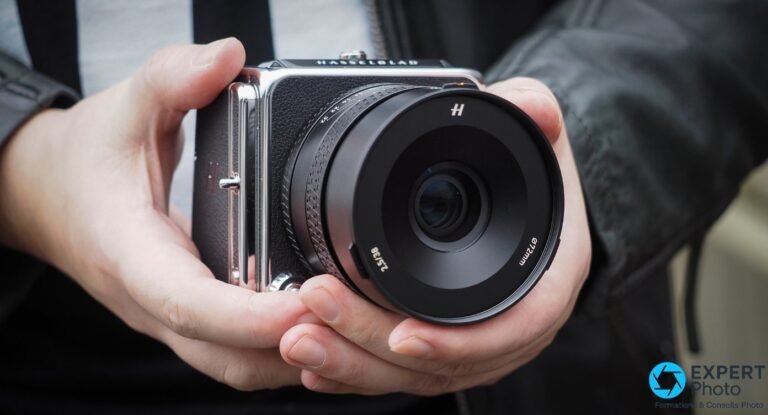Systeme Hasselblad 907X CFV 100C tenu en coupe dans deux mains, objectif 38 mm monte, logo H visible