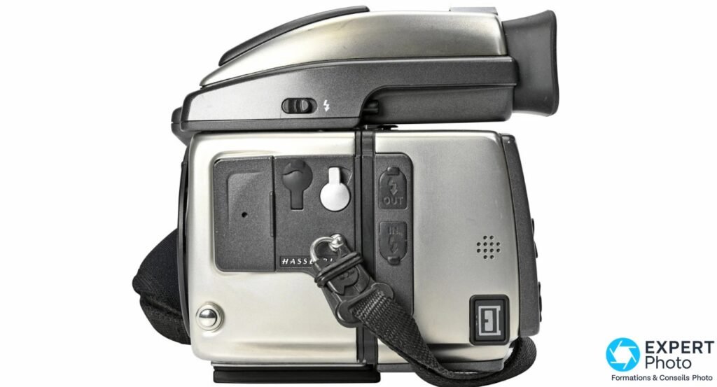 Hasselblad H4D-40 boîtier argenté vue de profil gauche, boutons OUT et IN flash visibles, dragonne noire fixée