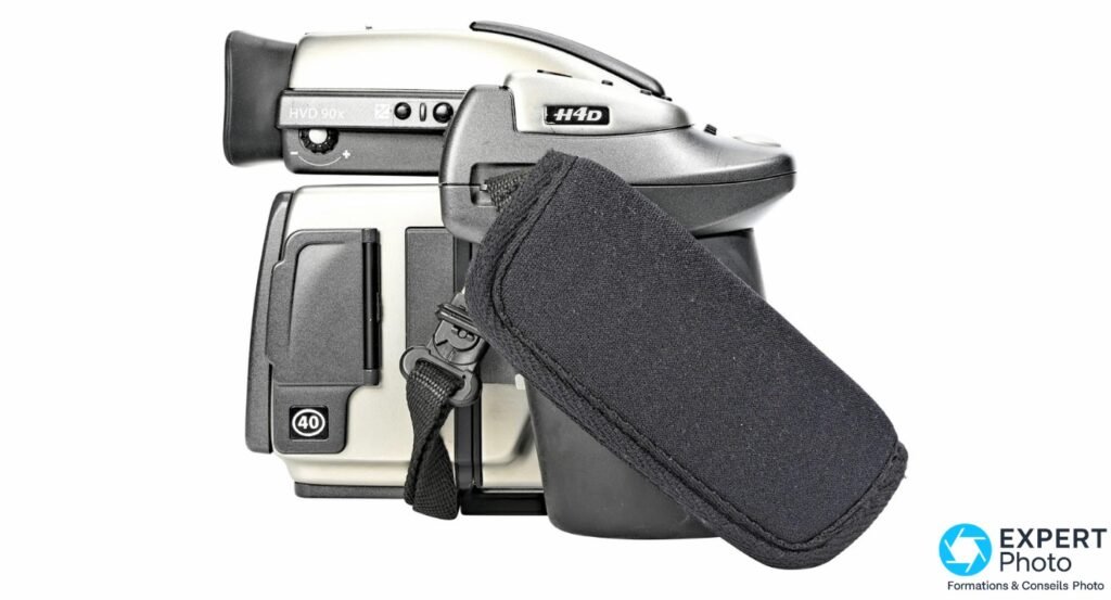 Hasselblad H4D-40 vue 3/4 arrière, viseur HVD 90x monté, dos numérique marqué 40, housse noire souple au premier plan