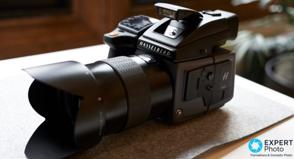 Hasselblad H6D-400c MS de trois quarts avant, flash integre releve, flanc du dos marque H et H6D
