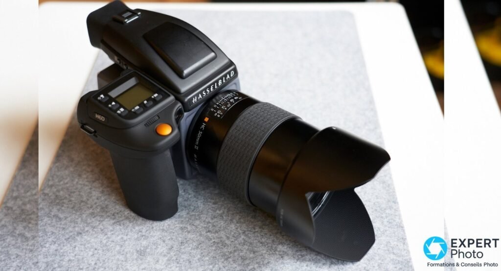 Hasselblad H6D-400c MS vu de dessus en biais, objectif HC 50 mm II et poignee a bouton orange