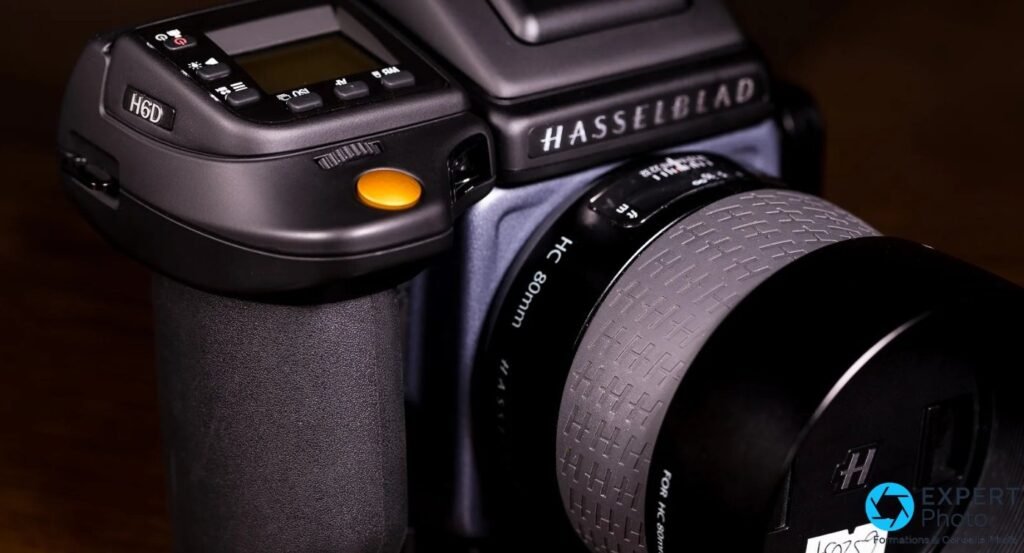 Dessus du Hasselblad H6D-50c : badge H6D, ecran de controle, declencheur orange et objectif HC 80 mm