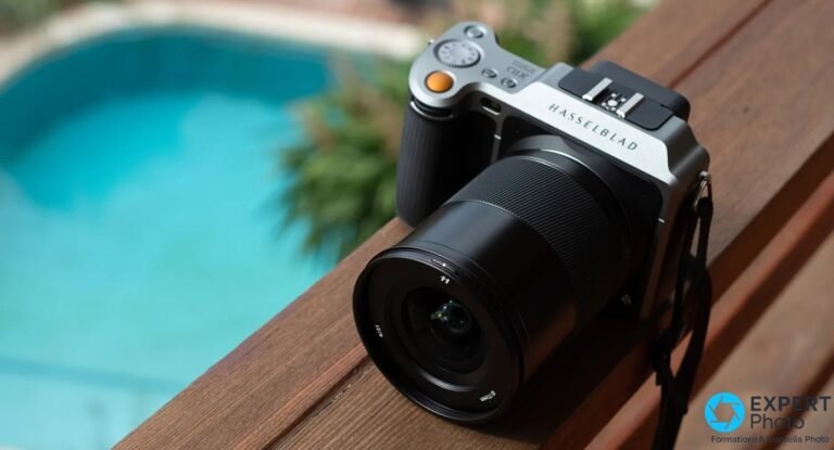 Hasselblad X1D-50c argent et noir, objectif XCD, posé sur une rambarde en bois devant une piscine floue