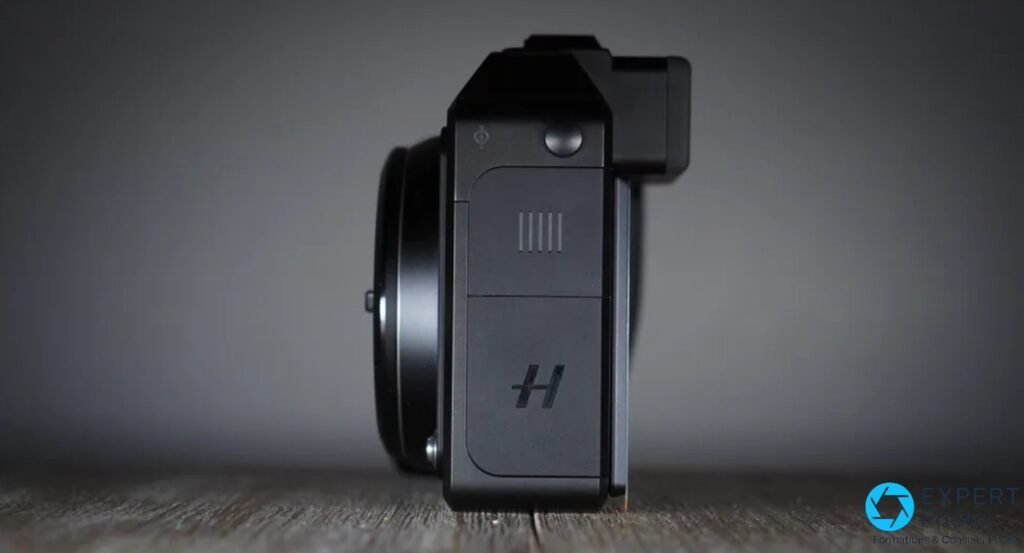 Hasselblad X2D 100C de profil : trappe latérale, logo H et monture sans objectif. 