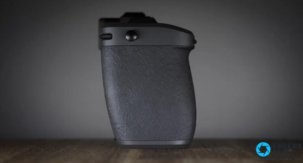 Profil du Hasselblad X2D II 100C montrant la poignee texturee, une molette crantee et un bouton sur le dessus. 