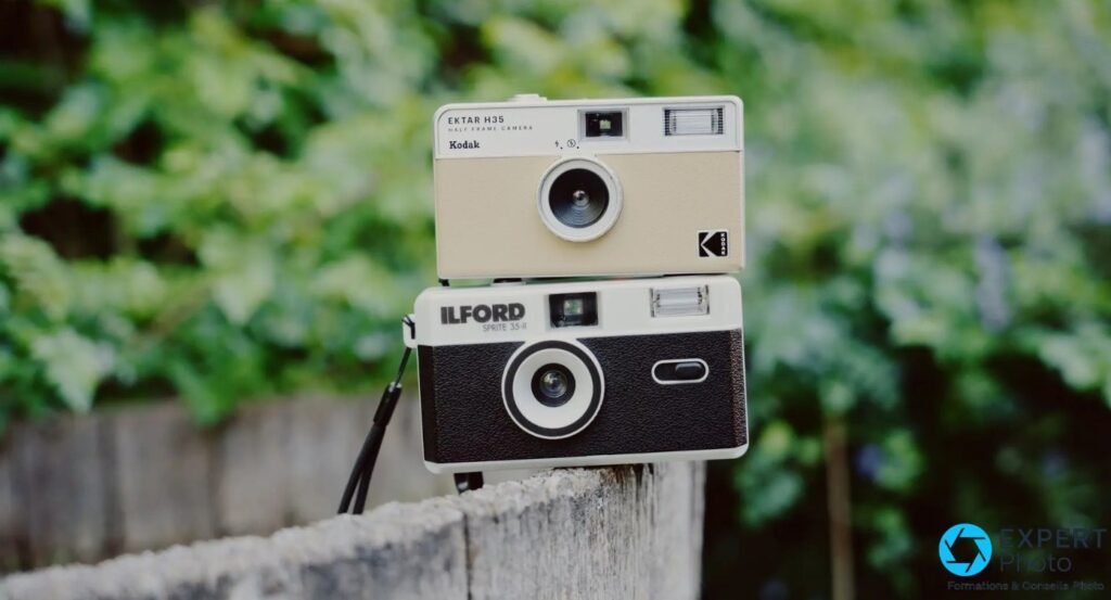 Kodak Ektar H35 beige posé sur un Ilford Sprite 35-II noir et argent, piquet en bois, feuillage vert flou 