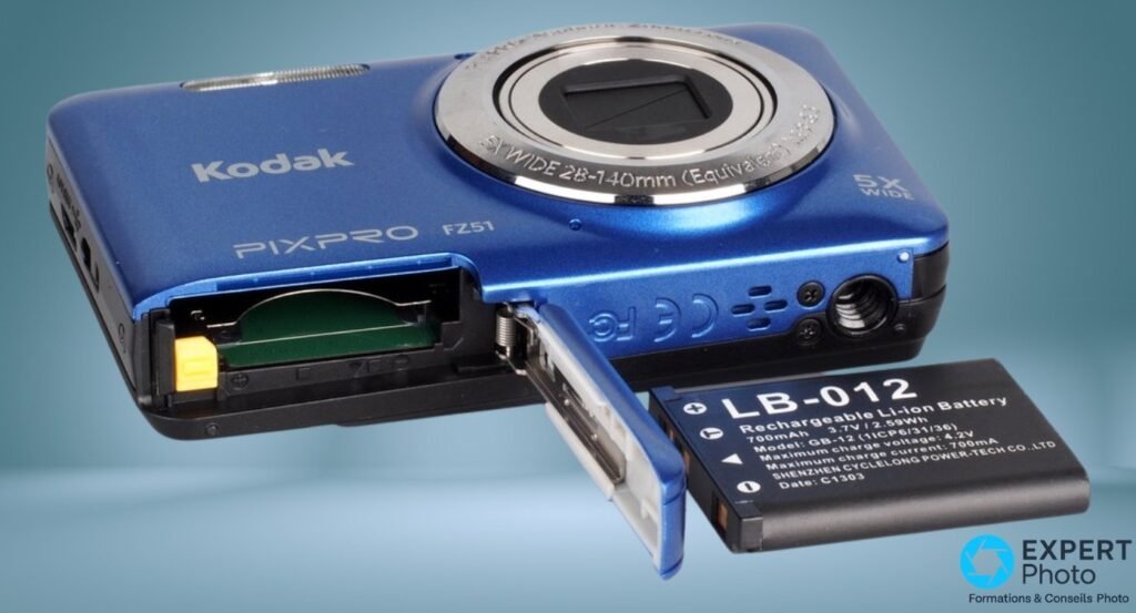 Compact Kodak PIXPRO FZ51 bleu, trappe ouverte sur logement carte SD vide, batterie LB-012 posée à côté 