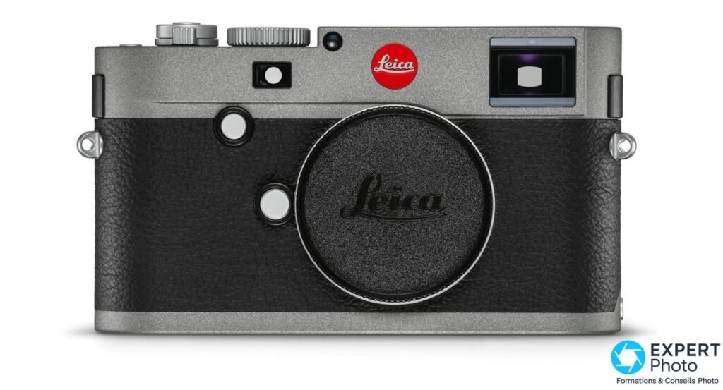 Leica M-E Typ 240 de face, boîtier nu, bouchon noir gravé Leica, top gris anthracite, cuir noir, point rouge, fond blanc.