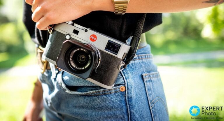 Leica M-E Typ 240 gris anthracite porté à la hanche, objectif Elmarit-M 1:2.8/28, scène extérieure, jean et montre dorée.