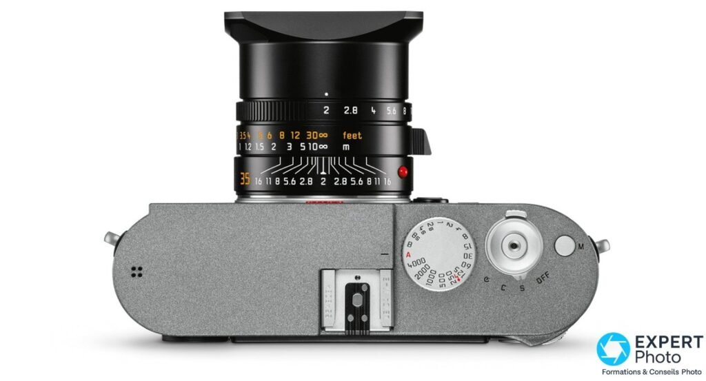 Leica M-E Typ 240 vu de dessus, objectif 35 mm monté avec pare-soleil carré, molette des vitesses, échelle de distances.