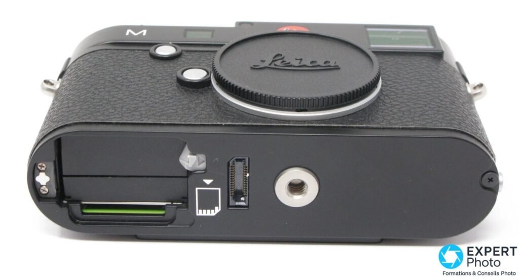  Leica M Typ 240 noir vu par-dessous, trappe batterie ouverte et carte SD verte visible dans son logement