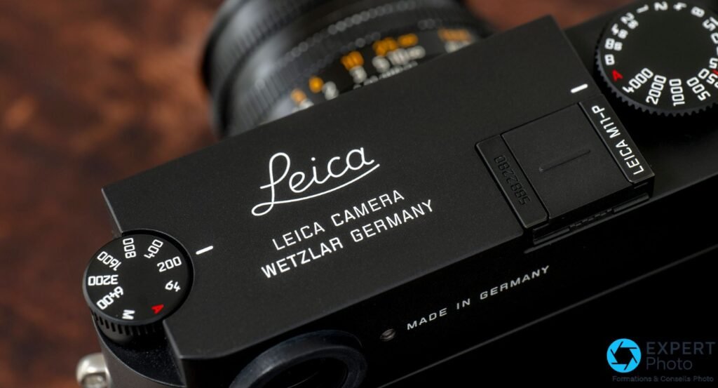 Détail de la platine supérieure du Leica M11-P noir, logo Leica en script et inscription Leica Camera Wetzlar Germany gravés