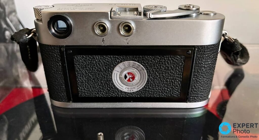 Dos d'un Leica M3 chrome : oculaire du viseur, deux prises synchro et molette de rappel ASA/DIN, dos en cuir noir. 