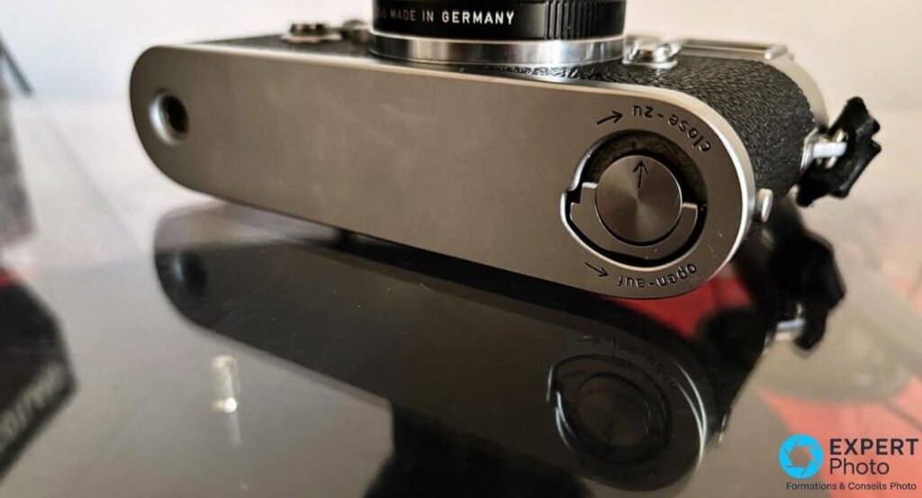 Semelle d'un Leica M3 chromee : verrou rotatif open-auf/close-zu et embase de trepied, objectif Made in Germany. 