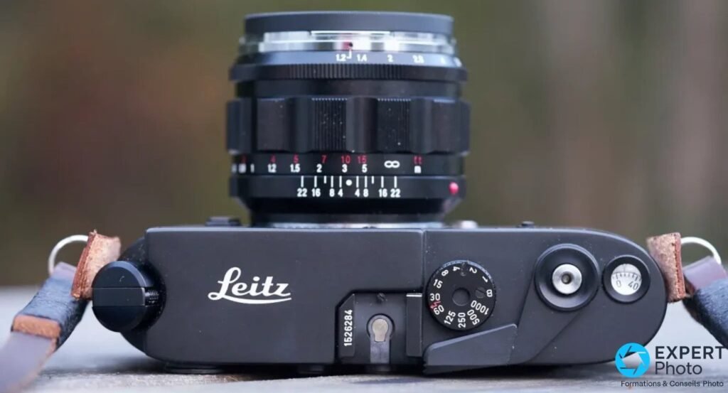 Top plate du Leica M4-2 noir avec gravure Leitz, numéro de série 1526284 et molette de vitesses, objectif au-dessus.