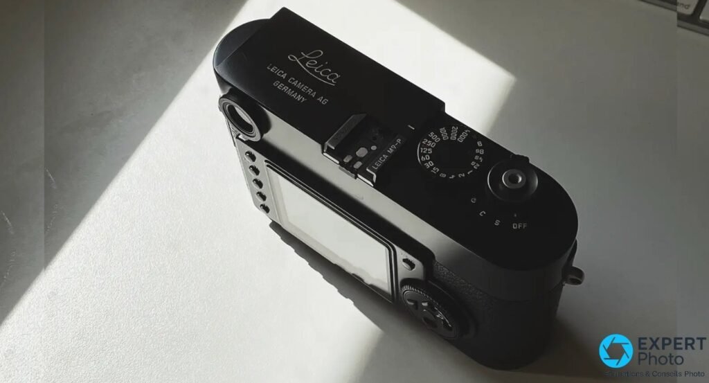 Dessus du Leica M9-P noir dans un faisceau de lumière, sabot grave Leica M9-P et molette de vitesses visibles