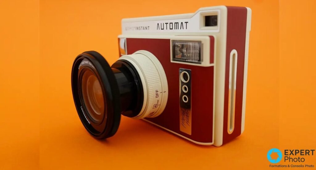 Lomo'Instant Automat de trois quarts avec une optique grand angle additionnelle montée, fond orange