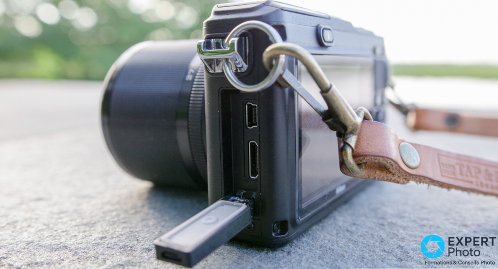 Nikon 1 AW1, trappe connectique latérale ouverte, port micro-USB et HDMI visibles, carte insérée en bas 
