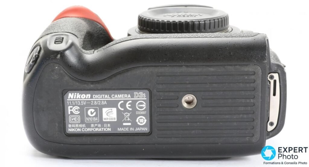  Etiquette de certification sous le Nikon D3s : reference D33697, marquage Made in Japan et filetage trepied. 